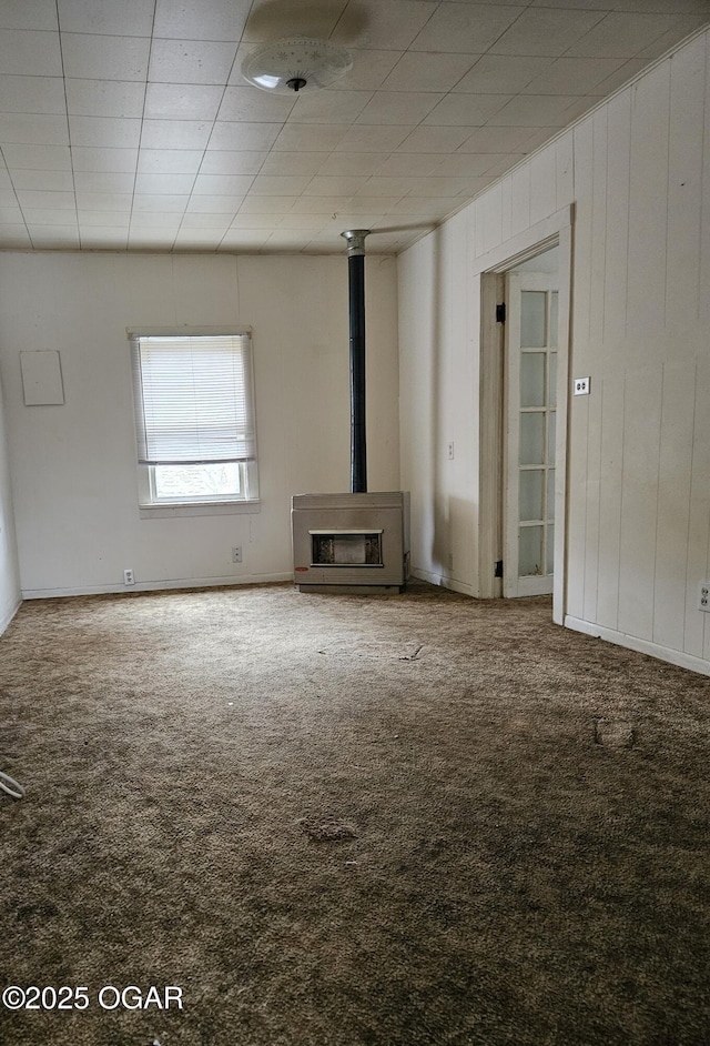 906 Randolph St, Neosho, MO 64850 - unfurnished living room featuring carpet flooring and a wood stove