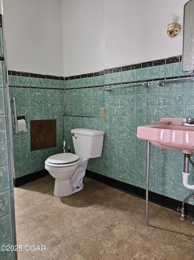906 Randolph St, Neosho, MO 64850 - bathroom with a sink, a wainscoted wall, toilet, and tile patterned floors