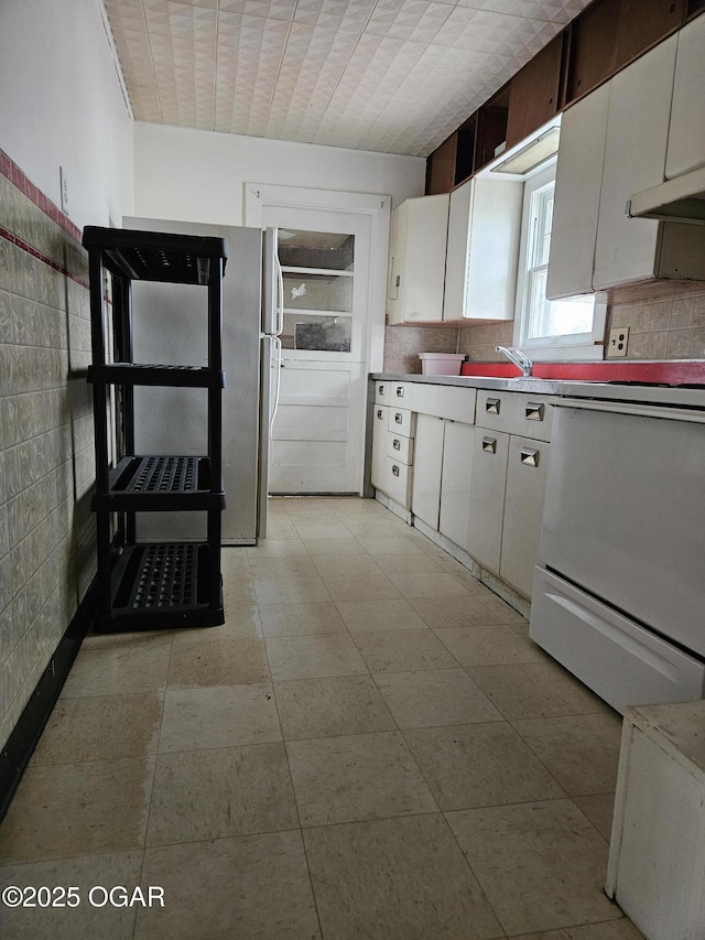906 Randolph St, Neosho, MO 64850 - kitchen with white cabinets, stove, and light countertops