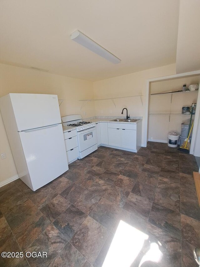514 S Cole, Granby, MO 64844 - kitchen with light countertops, stone finish flooring, a sink, white cabinetry, and white appliances