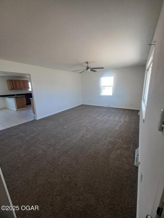 514 S Cole, Granby, MO 64844 - empty room featuring baseboards, ceiling fan, light tile patterned flooring, and light colored carpet