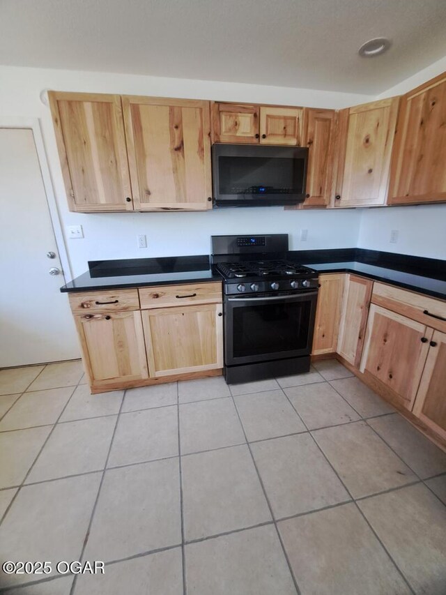 514 S Cole, Granby, MO 64844 - kitchen with light tile patterned flooring, dark countertops, black appliances, and light brown cabinetry