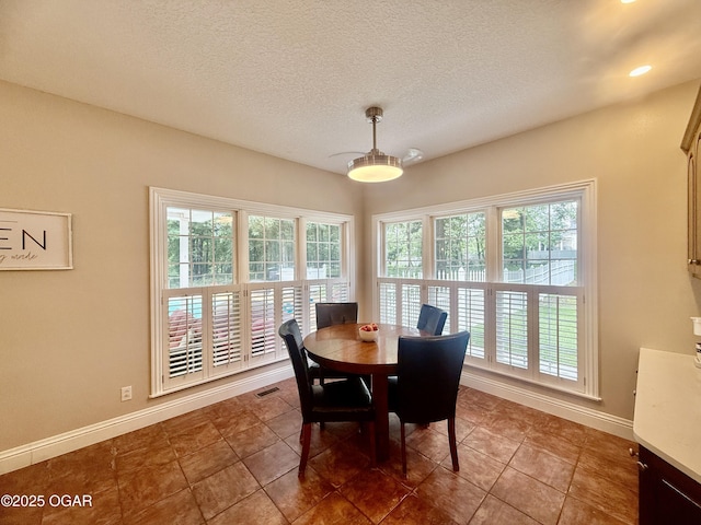 1911 Sherry Lea Dr, Neosho, MO 64850 - dining space featuring a textured ceiling, baseboards, and tile patterned flooring