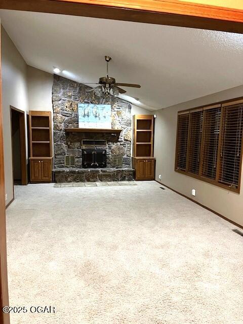 unfurnished living room featuring vaulted ceiling, a ceiling fan, carpet floors, and a fireplace