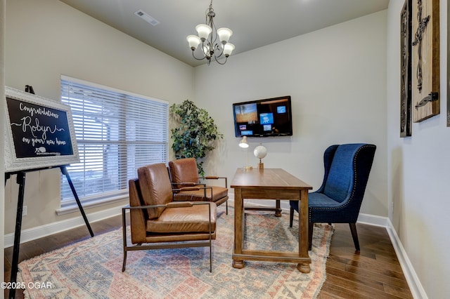 sitting room with an inviting chandelier, baseboards, wood finished floors, and visible vents