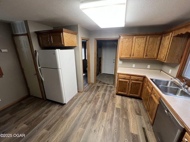 119 W Park St, Pittsburg, KS 66762 - kitchen featuring light wood-style flooring, a sink, freestanding refrigerator, dishwasher, and light countertops