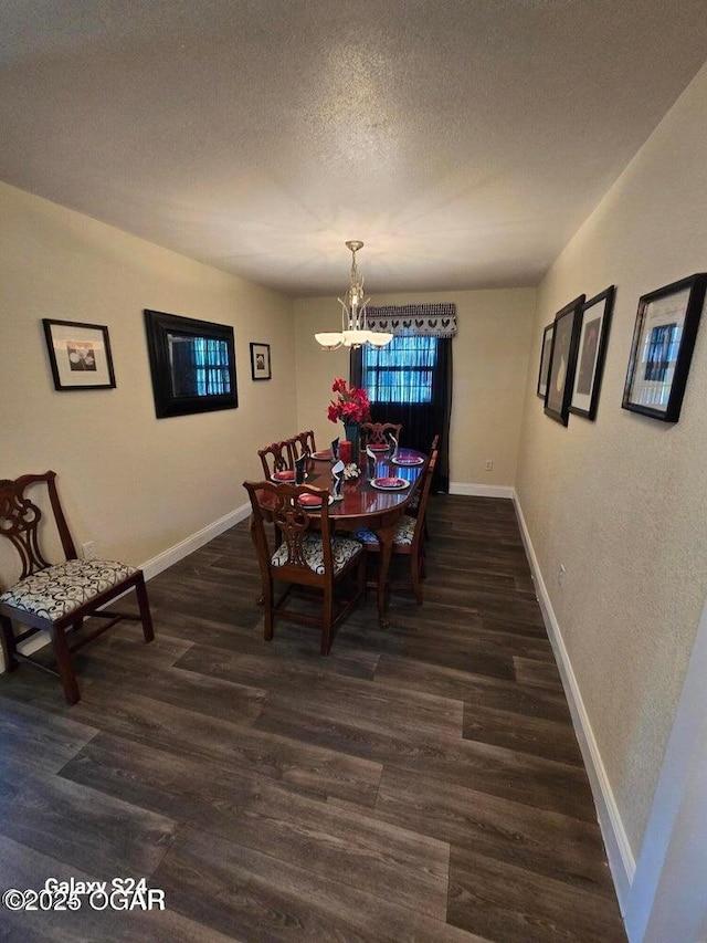 dining room featuring a notable chandelier, a textured ceiling, baseboards, and wood finished floors