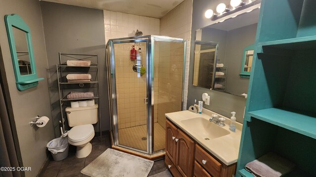 bathroom featuring a stall shower, toilet, tile patterned flooring, and vanity