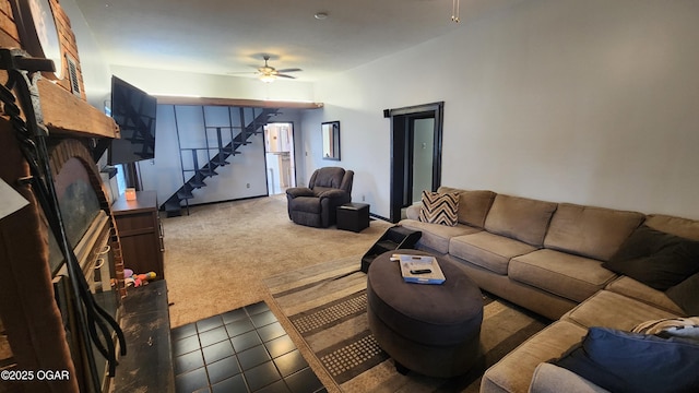 living area with stairs, ceiling fan, tile patterned flooring, and carpet floors