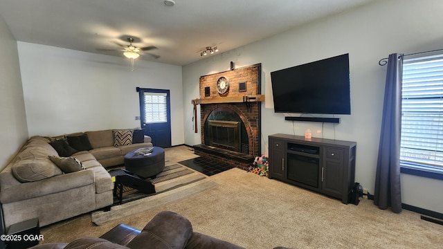 living area featuring light carpet, a brick fireplace, baseboards, visible vents, and ceiling fan
