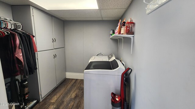 clothes washing area featuring dark wood finished floors, washing machine and dryer, and cabinet space