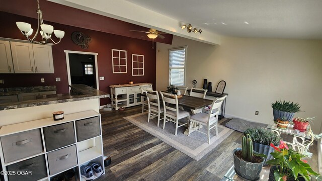 dining room featuring dark wood finished floors, ceiling fan with notable chandelier, and lofted ceiling