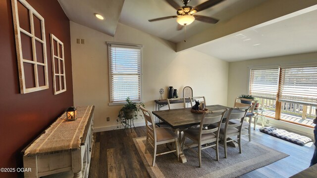 dining room featuring plenty of natural light, dark wood-type flooring, lofted ceiling, and visible vents