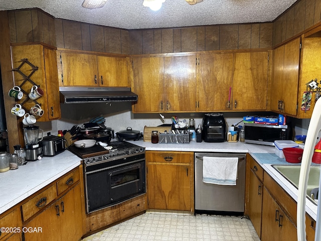 kitchen featuring stainless steel appliances, brown cabinetry, light floors, and extractor fan