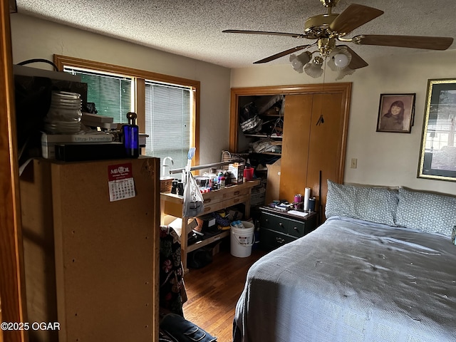 bedroom featuring a closet, a textured ceiling, wood finished floors, and a ceiling fan