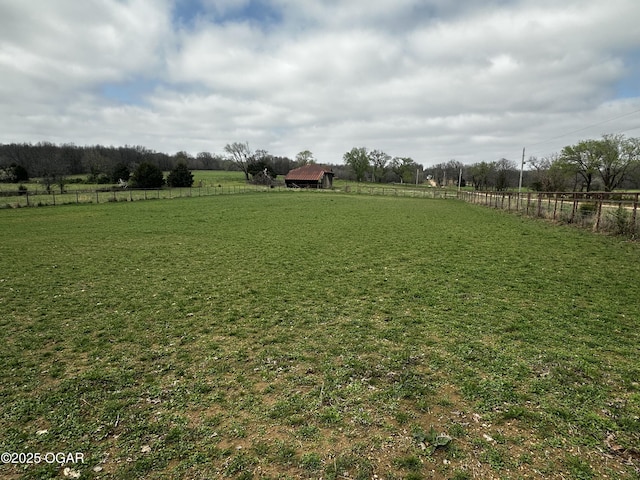 view of yard featuring fence and a rural view