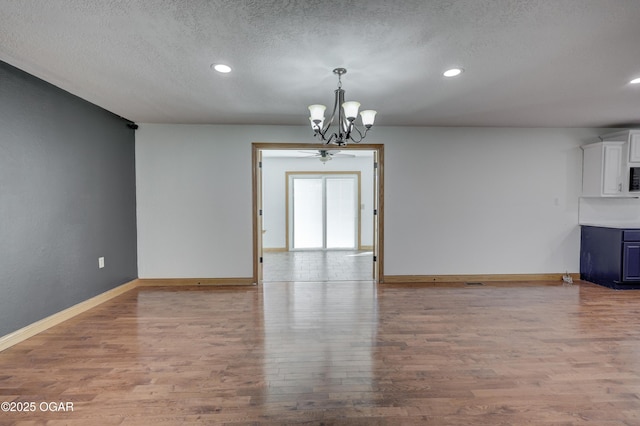 24600 State Highway 96, Webb City, MO 64870 - spare room with a notable chandelier, baseboards, recessed lighting, a textured ceiling, and wood finished floors