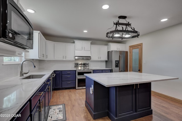 24600 State Highway 96, Webb City, MO 64870 - kitchen with light wood-style flooring, a kitchen island, white cabinets, appliances with stainless steel finishes, and a sink