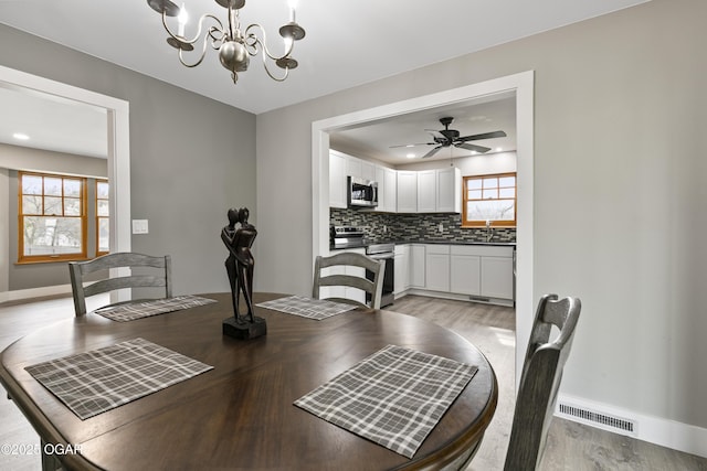 122 Valley View Dr, Joplin, MO 64804 - dining room with baseboards, ceiling fan with notable chandelier, light wood-style floors, and visible vents