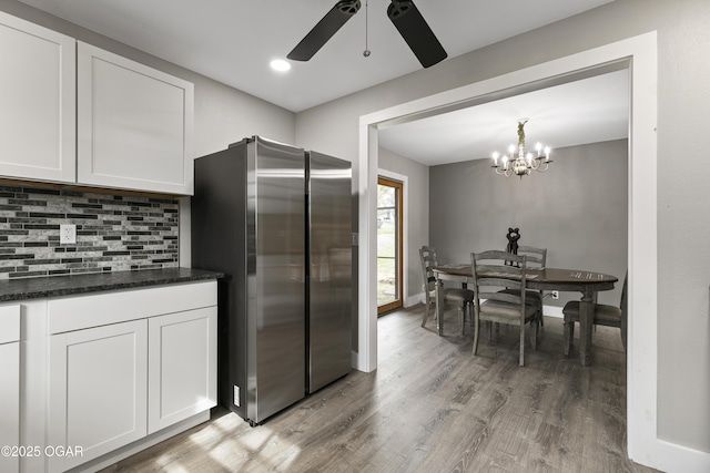 122 Valley View Dr, Joplin, MO 64804 - kitchen featuring freestanding refrigerator, ceiling fan with notable chandelier, white cabinets, light wood-style floors, and decorative backsplash