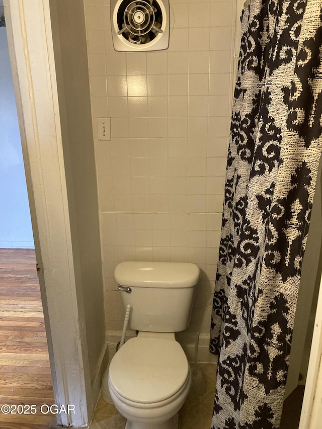 1320 W 4th St, Joplin, MO 64801 - full bathroom featuring toilet, curtained shower, wood finished floors, visible vents, and tile walls