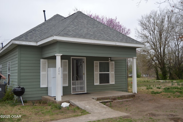 view of front of home with a porch and roof with shingles