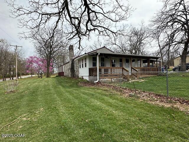 620 Hebron Rd, Granby, MO 64844 - view of property exterior featuring fence, a lawn, a chimney, and a porch