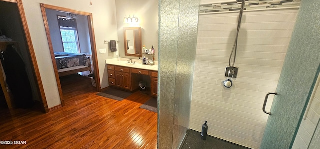 bathroom with ensuite bath, a tile shower, vanity, and wood finished floors