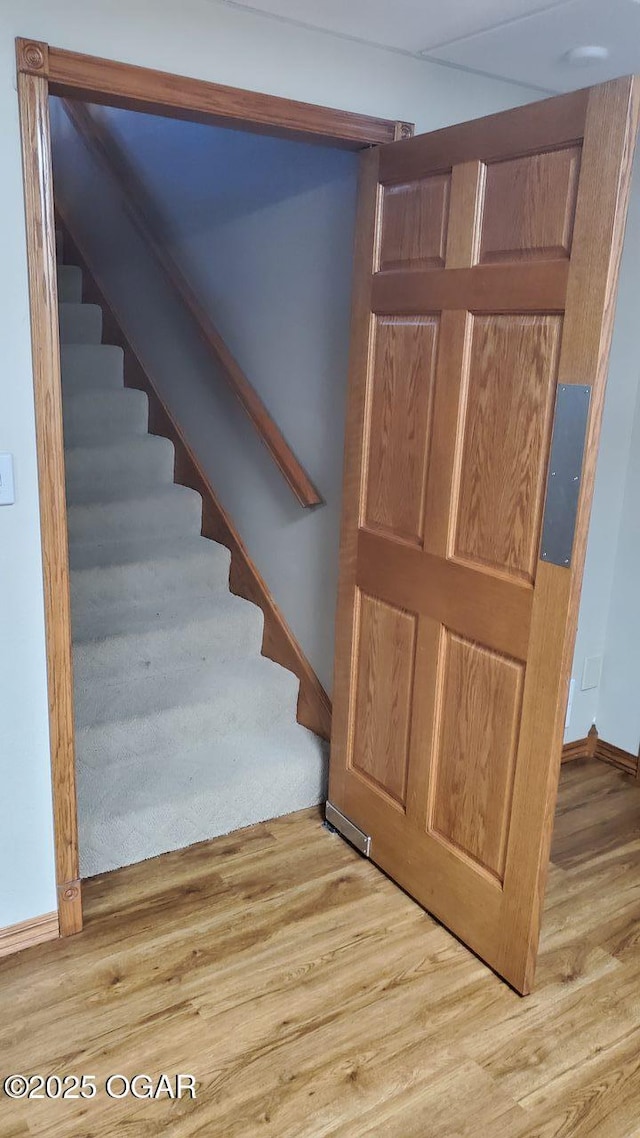 stairway featuring wood finished floors and baseboards