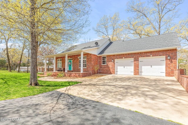 ranch-style home featuring a front yard, a garage, concrete driveway, brick siding, and roof with shingles