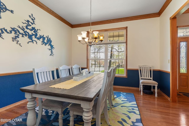 dining space with a wealth of natural light, an inviting chandelier, and wood finished floors