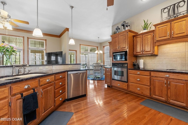 kitchen featuring a sink, tasteful backsplash, a ceiling fan, and stainless steel appliances