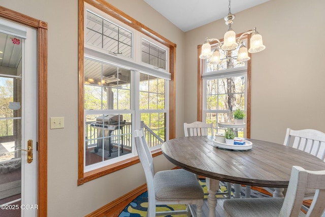 dining area with baseboards and a notable chandelier