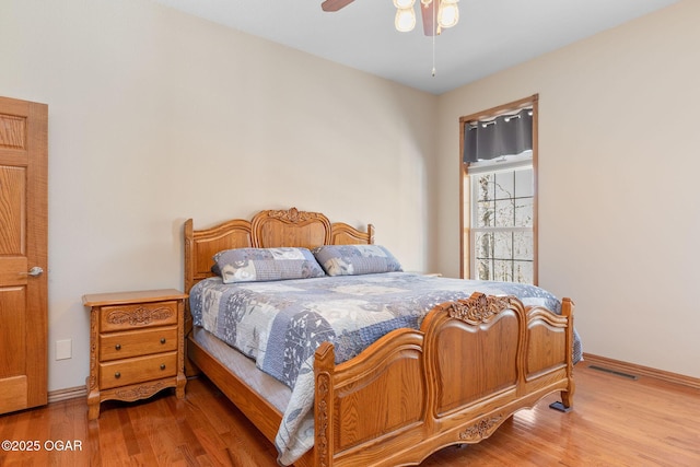 bedroom with wood finished floors, baseboards, a ceiling fan, and visible vents