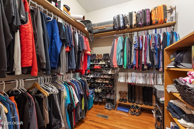 spacious closet featuring wood finished floors and visible vents