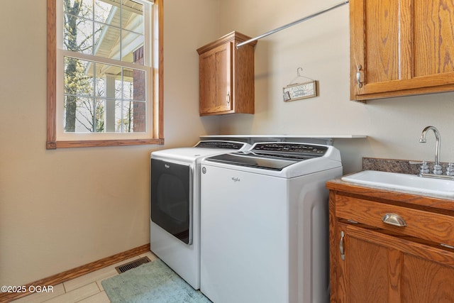 laundry room featuring baseboards, washing machine and dryer, visible vents, cabinet space, and a sink