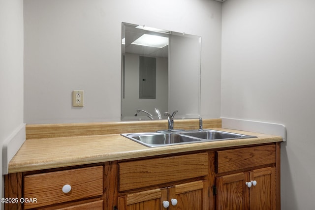 bathroom featuring electric panel and a sink