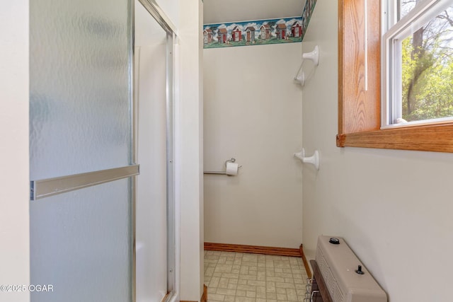 full bathroom featuring tile patterned floors, baseboards, and a stall shower