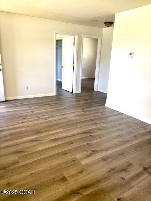 1530 S Oronogo St, Webb City, MO 64870 - spare room featuring baseboards and dark wood-type flooring
