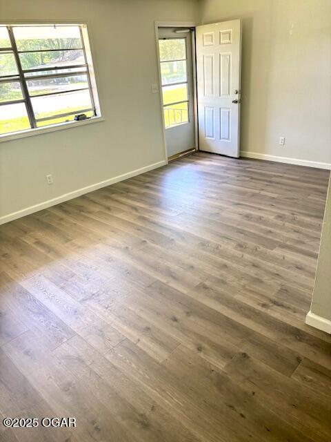 1530 S Oronogo St, Webb City, MO 64870 - empty room featuring healthy amount of natural light, wood finished floors, and baseboards