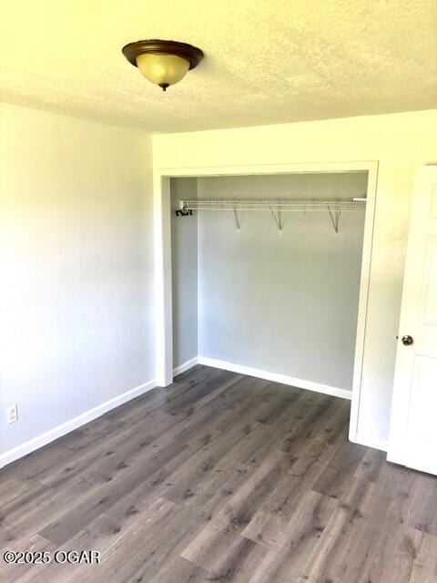 1530 S Oronogo St, Webb City, MO 64870 - unfurnished bedroom with a closet, baseboards, dark wood-style floors, and a textured ceiling