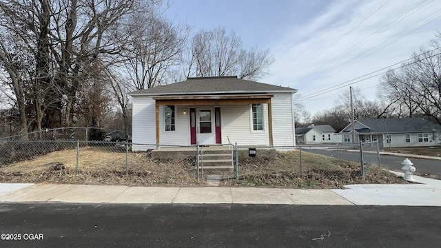 view of front of home with a porch, a gate, a fenced front yard, and a shingled roof