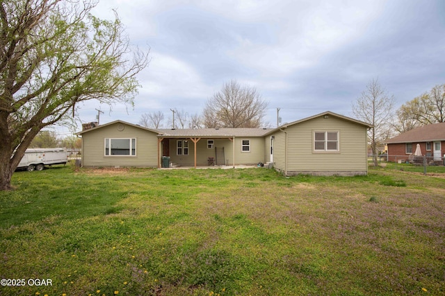 rear view of property with fence and a yard