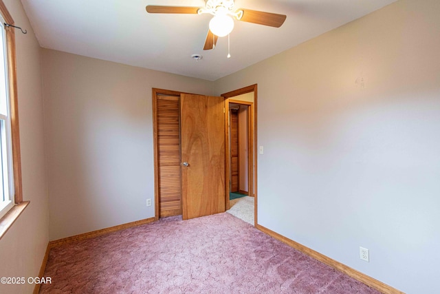 unfurnished bedroom with carpet, a closet, ceiling fan, and baseboards