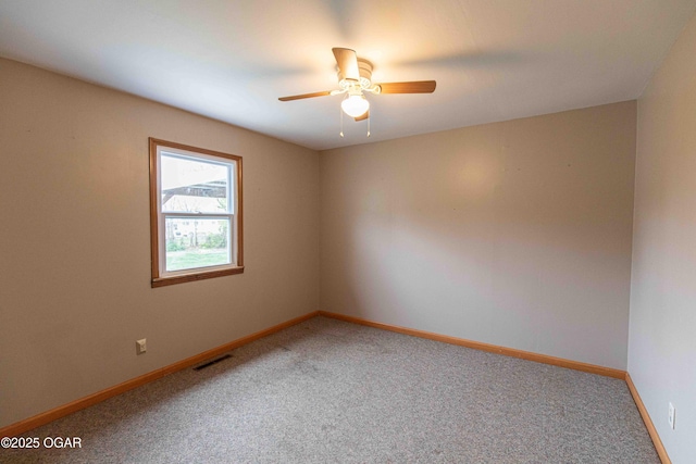empty room with baseboards, ceiling fan, visible vents, and carpet