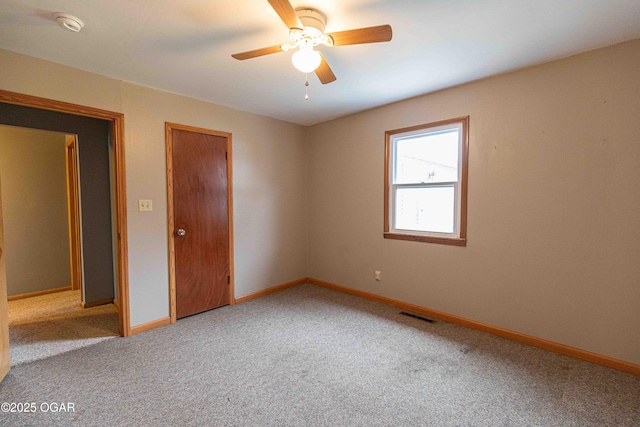 unfurnished bedroom featuring baseboards, visible vents, carpet floors, and a ceiling fan