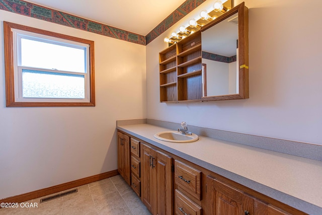 bathroom with tile patterned flooring, vanity, baseboards, and visible vents