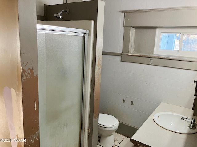 323 W Maple St, Columbus, KS 66725 - full bathroom with toilet, vanity, a stall shower, and tile walls