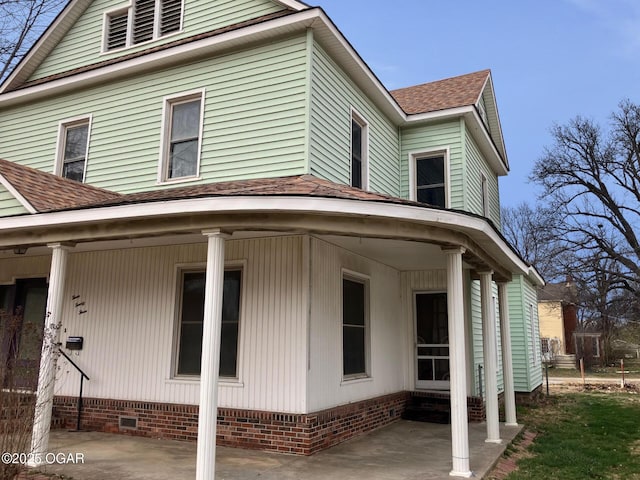 323 W Maple St, Columbus, KS 66725 - view of side of property featuring crawl space, a shingled roof, and a patio area
