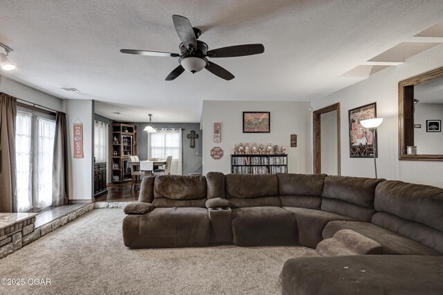 living room featuring ceiling fan, carpet, and a textured ceiling